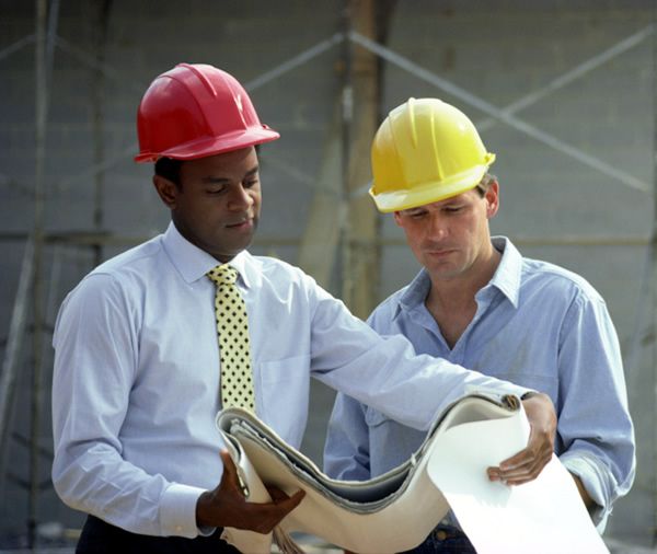 Contractors reviewing blueprints on a government construction project